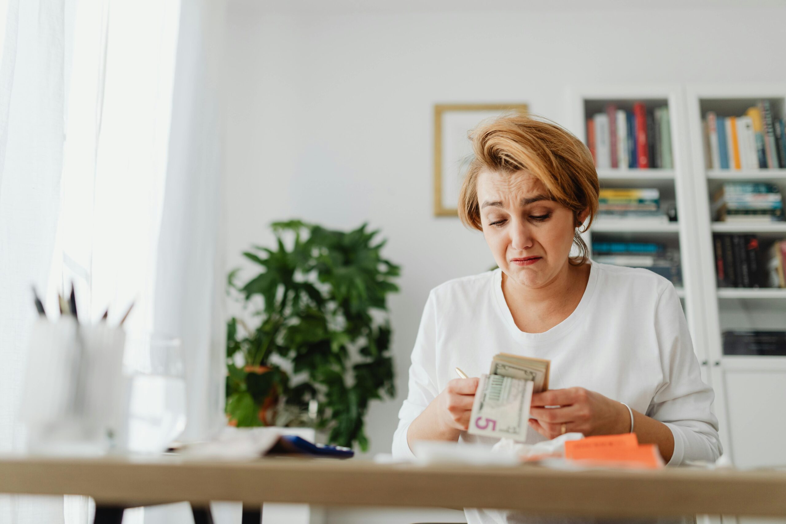 Stressed person reviewing bills and financial documents at home, symbolizing why 43% of U.S. workers say leaving their job would be too costly or difficult