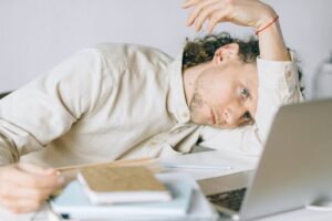 Exhausted worker sitting alone at office desk, head down, representing the growing workplace burnout crisis in America in 2026