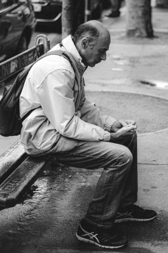A person sitting alone on city bench representing loneliness statistics in America