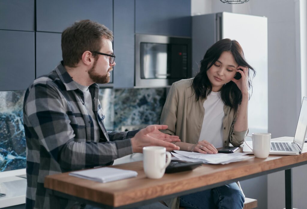 Couple reviewing medical bills at a kitchen table representing insured Americans carrying medical debt because the average silver plan deductible in 2026 is $5,304 — paid entirely out of pocket before insurance covers anything