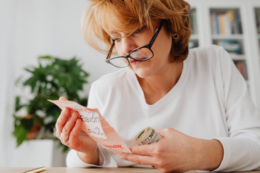 Person reviewing monthly bills at kitchen table representing middle-class financial stress in America 2026