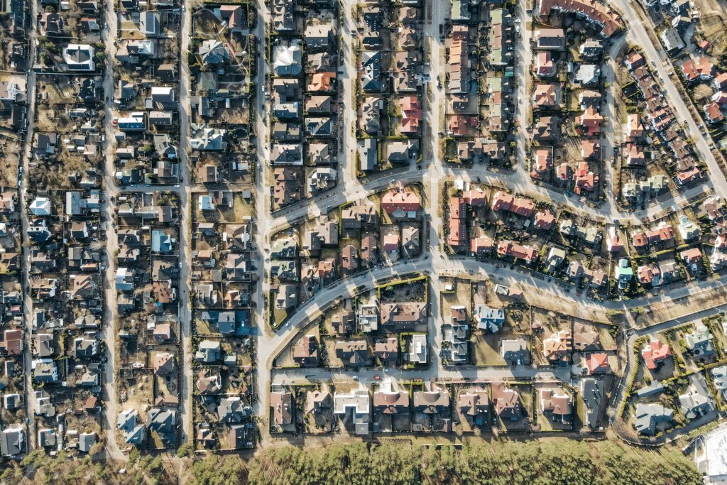 An aerial view of rows of identical suburban homes representing American neighborhoods being purchased by institutional investors and hedge funds who now own nearly 1 in 5 single-family homes, pricing out working families from homeownership