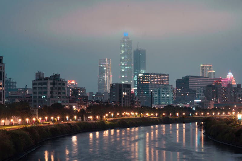A glowing American city skyline at night representing the Wired Belt metros like San Francisco, Boston, and New York that face the highest AI job displacement risk in 2026 — cities built on knowledge work that AI now automates most efficiently