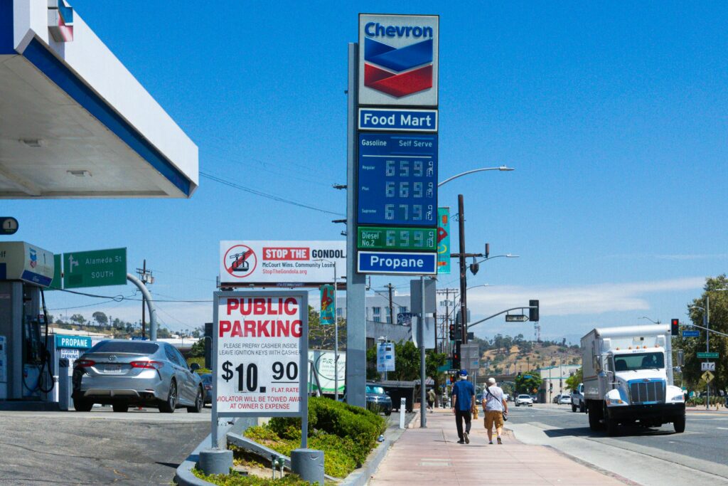 A roadside gas station price sign showing high fuel costs near $3.93 per gallon in America in 2026, amid rising energy prices tied to the Iran conflict and tariff-driven inflation